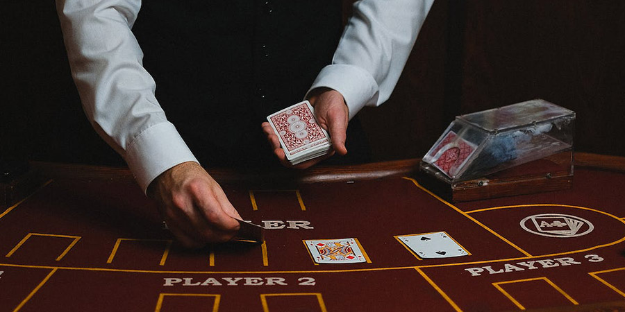 close up of a dealer's hands drawing cards on the table